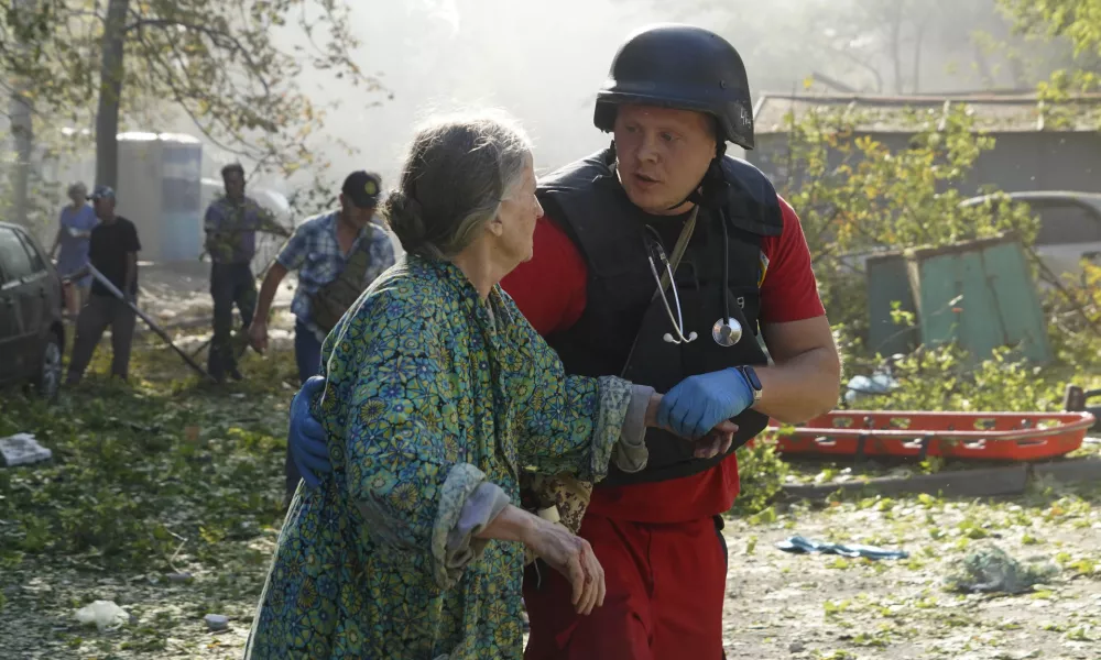 An elderly woman is assisted after a Russian aerial bomb struck a multi-story residential building in Kharkiv, Ukraine, Sunday Sept. 15, 2024. (AP Photo/Andrii Marienko)