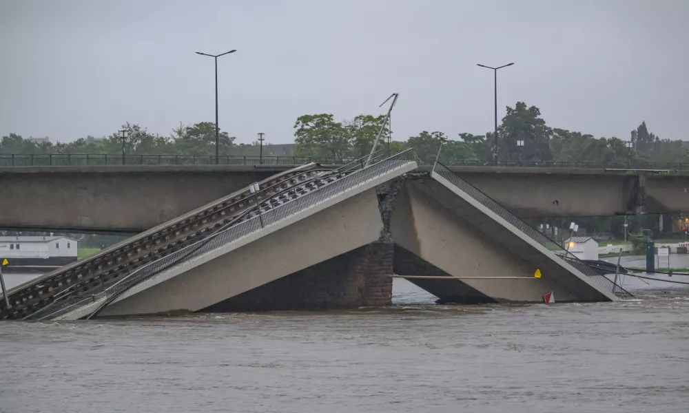 16 September 2024, Saxony, Dresden: The flooding Elbe flows along the partially collapsed Carola Bridge. According to the Saxon state capital, parts of the bridge in the water will cause the water to build up upstream, causing the water level on a section of the Elbe to rise by around 30 to 50 centimetres. Photo: Robert Michael/dpa