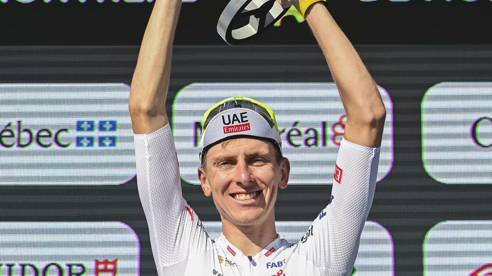 Tadej Pogacar, from Slovenia, raises his trophy after winning the Montreal Grand Prix cycling race in Montreal, Sunday, Sept. 15, 2024. (Graham Hughes/The Canadian Press via AP)