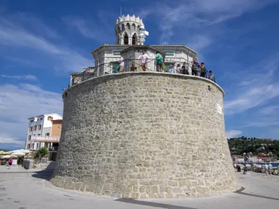 Our Lady of Health Church, Piran / Slovenia - June 24, 2018: Peninsula Piran coastline with church and tourists enjoying sunny day