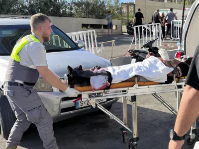 A Civil Defense first-responder carries a wounded man whose handheld pager exploded at al-Zahraa hospital in Beirut, Lebanon, Tuesday, Sept. 17, 2024. (AP Photo/Hussein Malla)