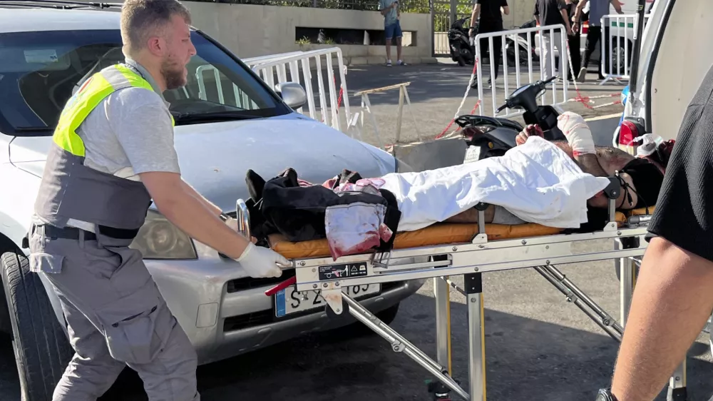 A Civil Defense first-responder carries a wounded man whose handheld pager exploded at al-Zahraa hospital in Beirut, Lebanon, Tuesday, Sept. 17, 2024. (AP Photo/Hussein Malla)