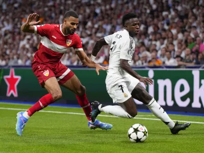 Real Madrid's Vinicius Junior, right, tussles for the ball with Stuttgart's Josha Vagnoman during the Champions League opening phase soccer match between Real Madrid and VfB Stuttgart at the Santiago Bernabeu stadium, in Madrid, Tuesday, Sept. 17, 2024. Real Madrid won 3-1. (AP Photo/Manu Fernandez)