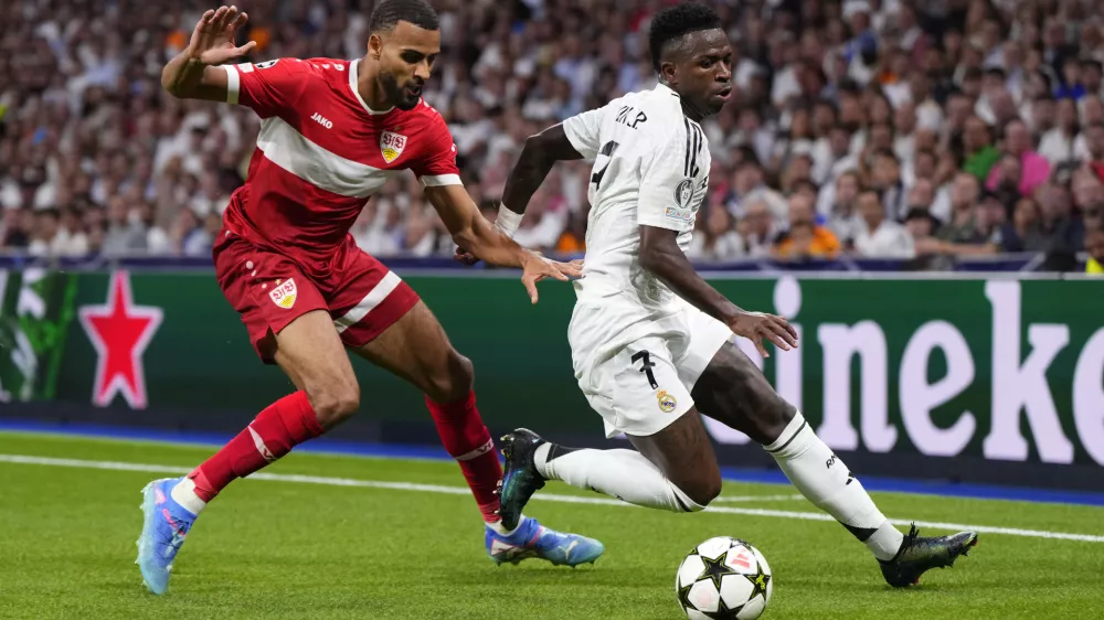 Real Madrid's Vinicius Junior, right, tussles for the ball with Stuttgart's Josha Vagnoman during the Champions League opening phase soccer match between Real Madrid and VfB Stuttgart at the Santiago Bernabeu stadium, in Madrid, Tuesday, Sept. 17, 2024. Real Madrid won 3-1. (AP Photo/Manu Fernandez)