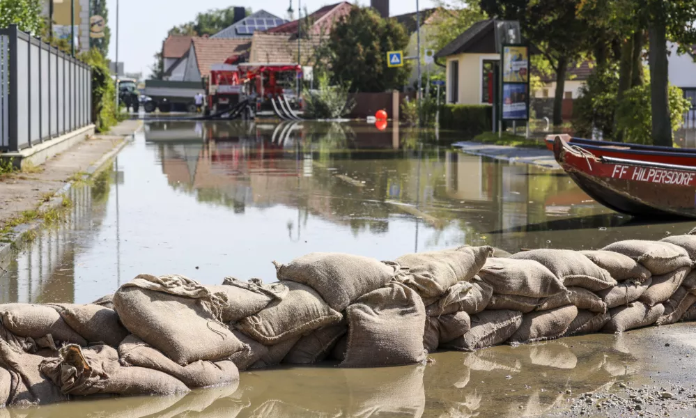 18 September 2024, Austria, Erpersdorf: Fire department use sand bags to prevent water from roads and fields in Kleinschoenbichl. Although the flood waters in Austria are receding slightly, the situation remains tense and there is still a threat of dam breaches and landslides. Photo: Christoph Reichwein/dpa