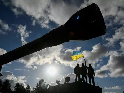 FILE PHOTO: Ukrainian personnel hold a Ukrainian flag as they stand on a Challenger 2 tank during training at Bovington Camp, near Wool in southwestern Britain, February 22, 2023. REUTERS/Toby Melville/File Photo