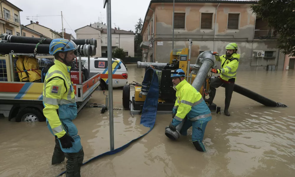 Workers try to pump away water after flooding in Faenza, in the region of Emilia Romagna, Italy, Thursday, Sept. 19, 2024. (Fabrizio Zani/LaPresse via AP)