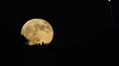 The moon rises in the sky over a freeway as drivers pass between Haifa and Tel Aviv, Israel, Wednesday, Sept. 18, 2024. (AP Photo/Ariel Schalit)