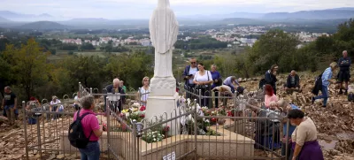 Pilgrims pray next to the statue of Virgin Mary on the Hill of appearance where it is believed that Virgin Mary showed herself and conveyed messages of peace to six children in Medjugorje, Bosnia, Thursday, Sept. 19, 2024. (AP Photo/Armin Durgut)