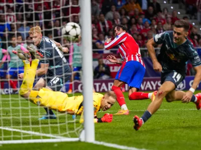 Atletico Madrid's Jose Gimenez, center, heads the ball to score his team's second goal past Leipzig's goalkeeper Peter Gulacsi during to the Champions League opening phase soccer match between Atletico Madrid and RB Leipzig at the Metropolitano stadium, in Madrid, Thursday, Sept. 19, 2024. Atletico Madrid won 2-1. (AP Photo/Manu Fernandez)