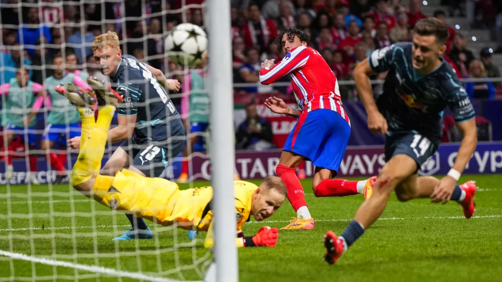 Atletico Madrid's Jose Gimenez, center, heads the ball to score his team's second goal past Leipzig's goalkeeper Peter Gulacsi during to the Champions League opening phase soccer match between Atletico Madrid and RB Leipzig at the Metropolitano stadium, in Madrid, Thursday, Sept. 19, 2024. Atletico Madrid won 2-1. (AP Photo/Manu Fernandez)