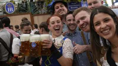 A waitress poses with guests at the Hofbraeuhaus beer tent on day one of the 189th 'Oktoberfest' beer festival in Munich, Germany, Saturday, Sept. 21, 2024. (AP Photo/Matthias Schrader)