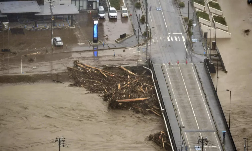 This aerial photo shows driftwoods piled around a bridge, caused by heavy rain in Wajima, Ishikawa prefecture, Saturday, Sept. 21, 2024. (Kyodo News via AP)