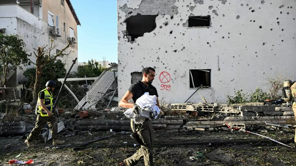 Security personnel carry debris and pieces of a rocket that damaged houses after it was fired from Lebanon into Israel, amid cross-border hostilities between Hezbollah and Israel, in Kiryat Bialik, northern Israel September 22, 2024. REUTERS/Rami Shlush ISRAEL OUT. NO COMMERCIAL OR EDITORIAL SALES IN ISRAEL