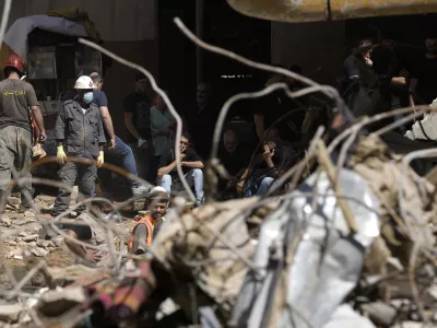 Emergency workers clear the rubble at the site of Friday's Israeli strike in Beirut's southern suburb, Sunday, Sept. 22, 2024. (AP Photo/Bilal Hussein)