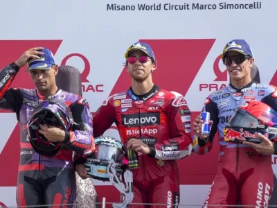 Race winner Italian rider Enea Bastianini of the Ducati Lenovo Team, center, poses on the podium with second placed Spain's rider Jorge Martin of the Prima Pramac Racing, left, and third placed Spain's rider Marc Marquez of the Gresini Racing MotoGP after the MotoGP race of the Emilia Romagna Motorcycle Grand Prix at the Misano circuit in Misano Adriatico, Italy, Sunday, Sept. 22, 2024. (AP Photo/Gregorio Borgia)