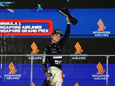 Formula One F1 - Singapore Grand Prix - Marina Bay Street Circuit, Singapore - September 22, 2024 McLaren's Lando Norris celebrates with a trophy after winning the Singapore Grand Prix REUTERS/Edgar Su