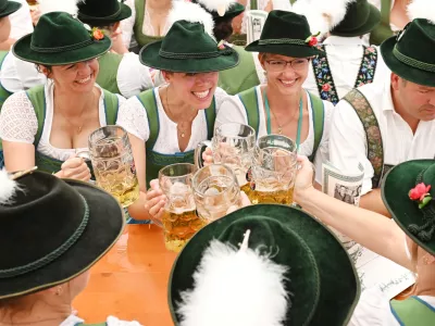 People dressed in traditional clothes sit in a tent during the 189th Oktoberfest, the world's largest beer festival in Munich, Germany, September 22, 2024. REUTERS/Angelika Warmuth