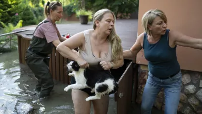 FILE - Women save a cat from floods in Szentendre, near Budapest, Hungary, Sept. 19, 2024. (AP Photo/Denes Erdos)