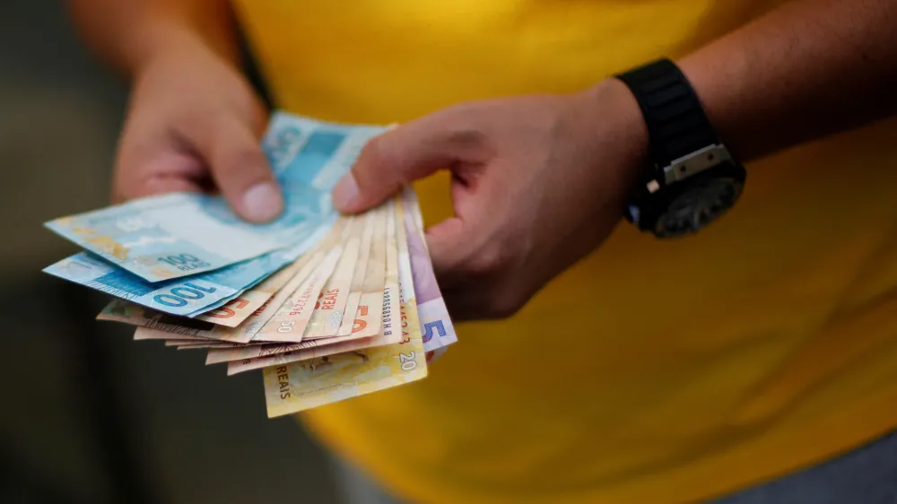 FILE PHOTO: A man counts betting money while watching the round of 16 soccer match for the 2014 World Cup between Brazil and Chile, during a gathering in a home in the upper class neighborhood of Lago Sul in Brasilia, June 28, 2014. REUTERS/Ueslei Marcelino/File Photo