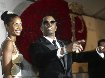 FILE - Sean "P. Diddy" Combs directs photographers as they sing "Happy Birthday," to him as his date Kim Porter, left, listens, after Combs arrived for his 35th birthday celebration at Cipriani on Wall Street in New York, Nov. 4, 2004. (AP Photo/Kathy Willens, File)