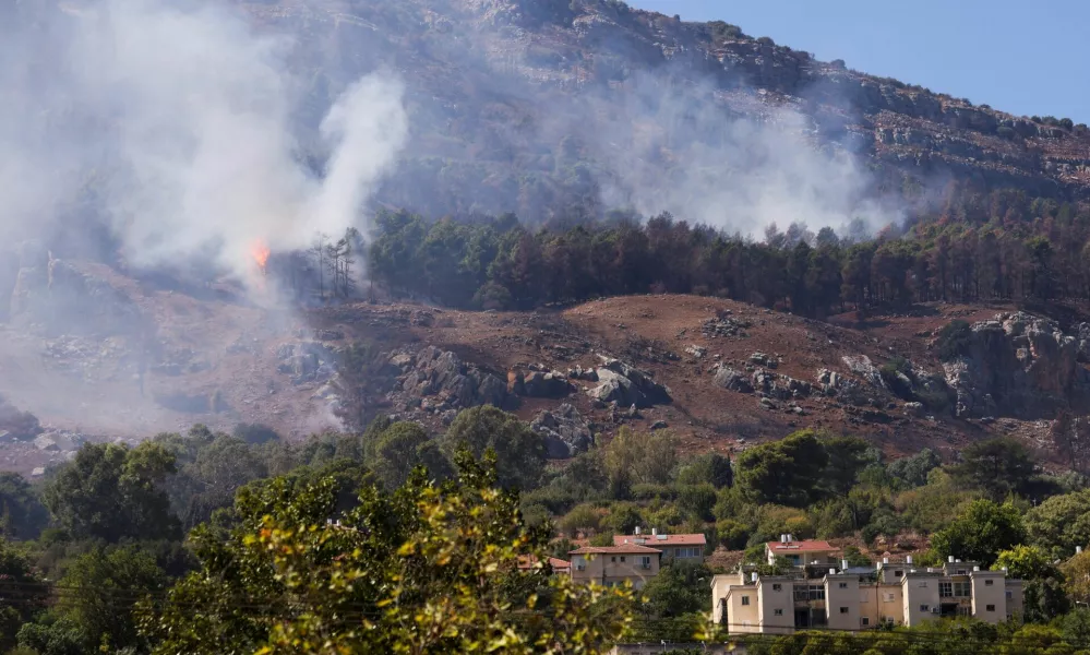 Smoke and flames are visible near homes in Kiryat Shmona after a rocket attack launched from Lebanon, amid cross-border hostilities between Hezbollah and Israel, in northern Israel, September 26, 2024. REUTERS/Jim Urquhart