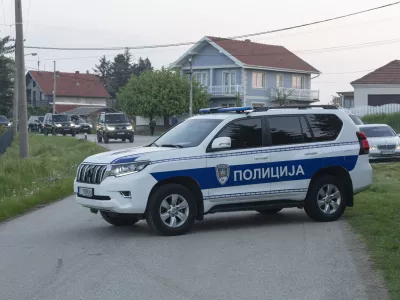 A police vehicle blocks the entrance to the village of Dubona, some 40 kilometers south of Belgrade, Serbia, Friday, May 5, 2023. A shooter killed multiple people and wounded more in a drive-by attack late Thursday in Serbia's second such mass killing in two days, state television reported. (AP Photo/Marko Drobnjakovic)