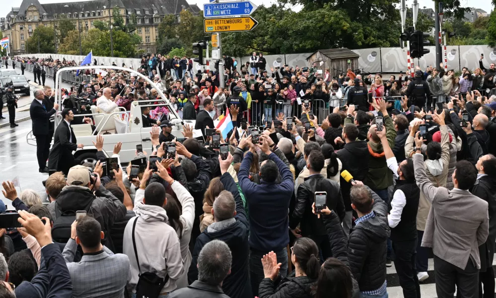 26 September 2024, Luxembourg: Pope Francis waves to the people while traveling in the Popamobile during his visit to Luxembourg. Photo: Harald Tittel/dpa