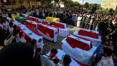 27 September 2024, Lebanon, Maaysra: Lebanese clerics pray over the coffins of 16 people, including three Hezbollah militants, who were killed in an Israeli airstrike on the village of Maaysra, north of Beirut. Photo: Marwan Naamani/dpa