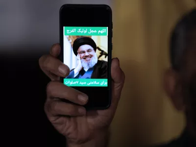 An Iranian demonstrator shows a portrait of Hezbollah leader Hassan Nasrallah on his cell phone in support of Hezbollah at the Felestin (Palestine) Square in downtown Tehran, Iran, early Saturday, Sept. 28, 2024. (AP Photo/Vahid Salemi)