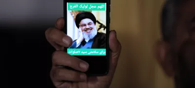 An Iranian demonstrator shows a portrait of Hezbollah leader Hassan Nasrallah on his cell phone in support of Hezbollah at the Felestin (Palestine) Square in downtown Tehran, Iran, early Saturday, Sept. 28, 2024. (AP Photo/Vahid Salemi)