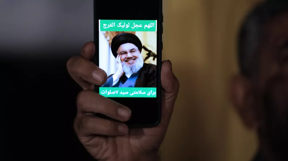 An Iranian demonstrator shows a portrait of Hezbollah leader Hassan Nasrallah on his cell phone in support of Hezbollah at the Felestin (Palestine) Square in downtown Tehran, Iran, early Saturday, Sept. 28, 2024. (AP Photo/Vahid Salemi)