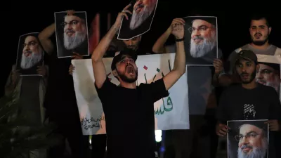 Lebanese and Palestinian men hold portraits of Hezbollah leader Sayyed Hassan Nasrallah, as they shout slogans during a protest in the southern port city of Sidon, Lebanon, Saturday, Sept. 28, 2024. (AP Photo/Hussein Malla)