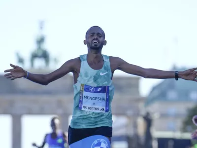 Milkesa Mengesha from Ethiopia celebrates as he crosses the finish line to win the men's division of the Berlin Marathon in Berlin, Germany, Sunday, Sept. 29, 2024. (AP Photo/Ebrahim Noroozi)