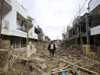 A man walks on a street strewn with debris in Kathmandu, Nepal, Monday, Sept. 30, 2024 in the aftermath of a flood caused by heavy rains. (AP Photo/Gopen Rai)