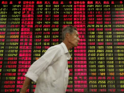 An investor walks past stock price monitor at a private securities company Thursday, Oct. 22, 2009 in Shanghai, China. China's economy expanded 8.9 percent in the third quarter, pumped up by easy credit and massive government spending that have ensured a recovery while the U.S., Japan and Europe continue to flounder. (AP Photo/Eugene Hoshiko)