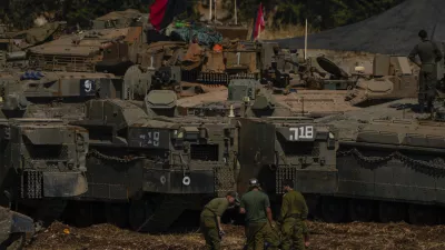 Israeli soldiers work on tanks and APC in northern Israel on Sunday, Sept. 29, 2024. (AP Photo/Ariel Schalit)