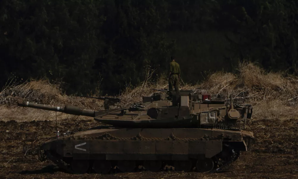 Israeli soldiers work on tanks in northern Israel on Sunday, Sept. 29, 2024. (AP Photo/Ariel Schalit)