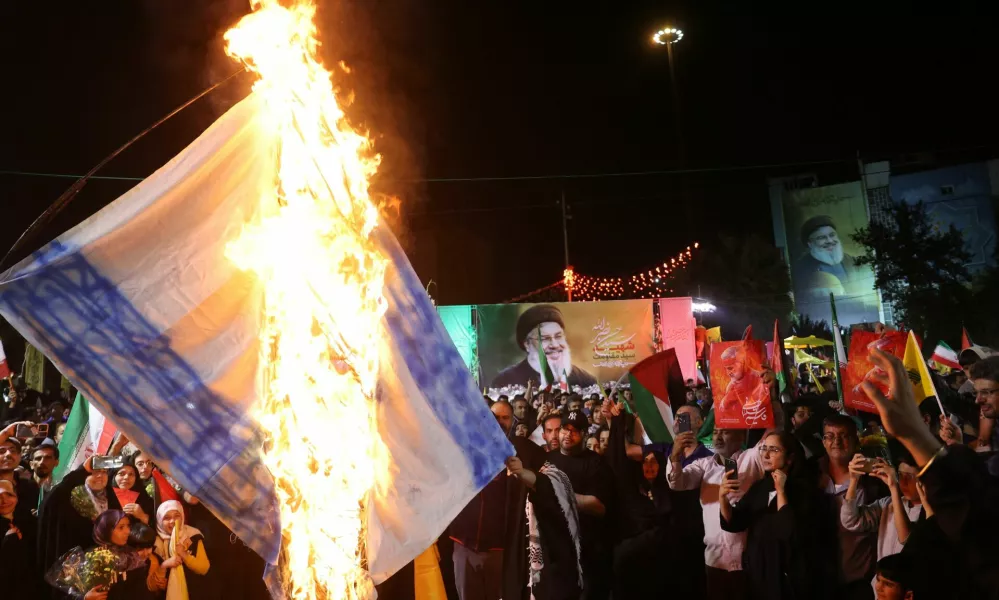 Iranians burn an Israeli flag during a celebration after the IRGC attack on Israel, in Tehran, Iran, October 1, 2024. Majid Asgaripour/WANA (West Asia News Agency) via REUTERS ATTENTION EDITORS - THIS IMAGE HAS BEEN SUPPLIED BY A THIRD PARTY  ATTENTION EDITORS - THIS PICTURE WAS PROVIDED BY A THIRD PARTY