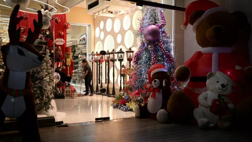 A woman cleans a store with Christmas decorations, as the Christmas season kicks off as per a decree of Venezuela's President Nicolas Maduro, in Caracas, Venezuela October 1, 2024. REUTERS/Gaby Oraa