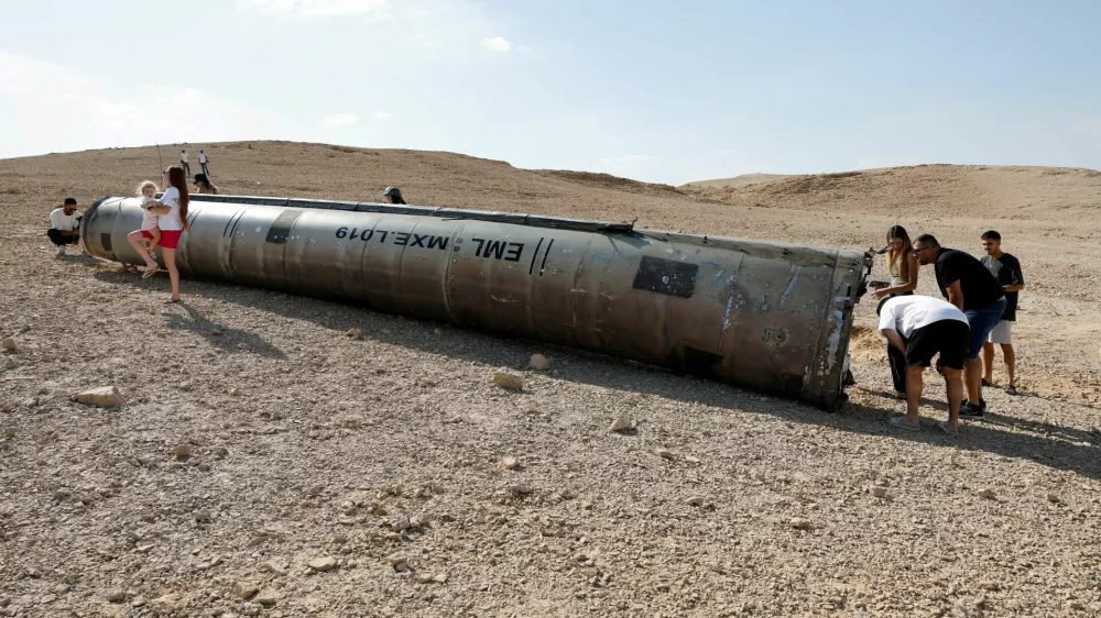 People look at apparent remains of a ballistic missile lying in the desert, following an attack by Iran on Israel, near the southern city of Arad, Israel October 2, 2024. REUTERS/Amir Cohen   TPX IMAGES OF THE DAY