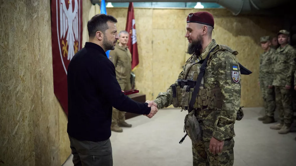 Ukraine's President Volodymyr Zelenskiy shakes hands with a service member during his visit to a position of Ukrainian troops, in the course of Russia-Ukraine conflict, in Sumy region, Ukraine October 4, 2024. Ukrainian Presidential Press Service/Handout via REUTERS ATTENTION EDITORS - THIS IMAGE HAS BEEN SUPPLIED BY A THIRD PARTY.