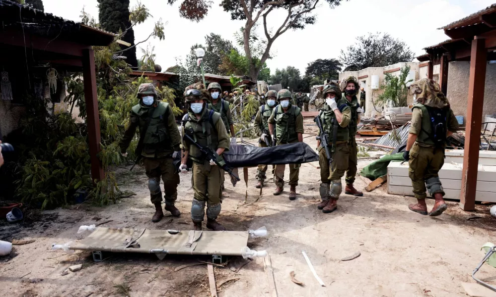 FILE PHOTO: Israeli soldiers carry the body of a victim of an attack by militants from Gaza at Kibbutz Kfar Aza, in southern Israel, October 10, 2023. REUTERS/Ronen Zvulun/File Photo