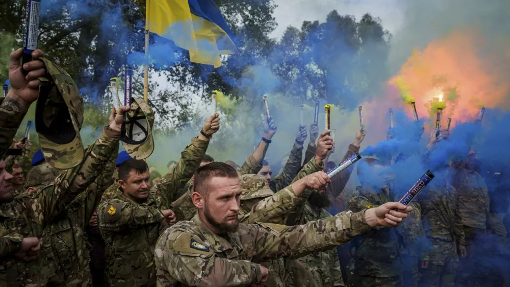 Ukrainian servicemen of the Azov brigade light flares during the funeral ceremony of fallen comrade Ihor Kusochek, in Travkine, Chernihiv region, Ukraine, Friday Oct. 4, 2024. (AP Photo/Evgeniy Maloletka)