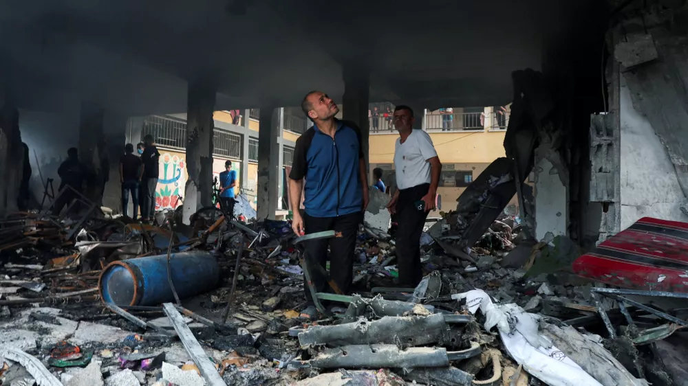 Palestinians inspect the site of an Israeli strike on a school sheltering displaced people, amid Israel-Hamas conflict, in Deir Al-Balah, in the central Gaza Strip, October 6, 2024. REUTERS/Ramadan Abed   TPX IMAGES OF THE DAY