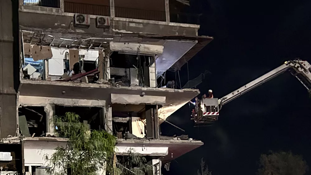 Rescue workers on a crane check a damaged building hit by an Israeli strike in Damascus, Syria, Tuesday, Oct. 8, 2024. (AP Photo/Omar Sanadiki)