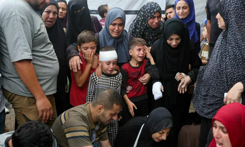 Children react next to the bodies of Palestinians, who were killed in Israeli strikes, amid the Israel-Hamas conflict, at Al-Aqsa Martyrs Hospital in Deir Al-Balah in the central Gaza Strip, October 8, 2024. REUTERS/Ramadan Abed   TPX IMAGES OF THE DAY