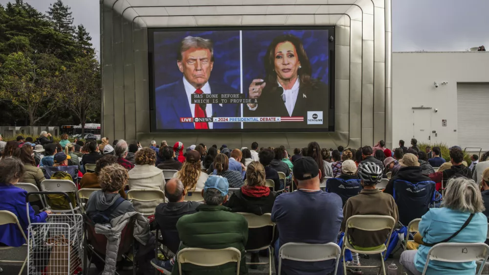 People gather outside of the Berkeley Art Museum and Pacific Film Archive to watch a presidential debate between Republican presidential nominee former President Donald Trump and Democratic presidential nominee Vice President Kamala Harris in Berkeley, Calif., Tuesday, Sept. 10, 2024. (Gabrielle Lurie/San Francisco Chronicle via AP)