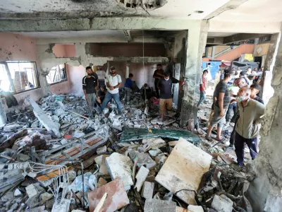 Palestinians inspect the site of an Israeli strike on a school sheltering displaced people, amid Israel-Hamas conflict, in Deir Al-Balah, in the central Gaza Strip, October 10, 2024. REUTERS/Ramadan Abed