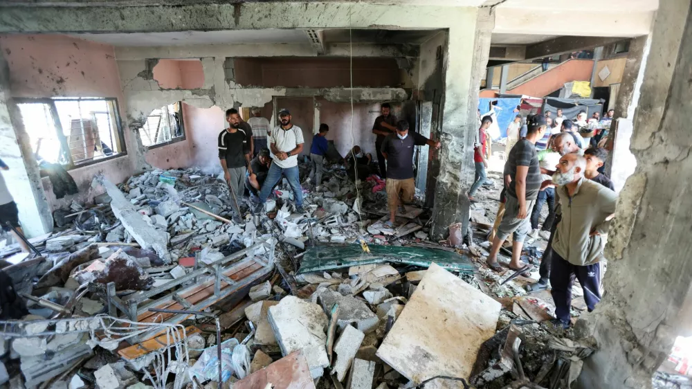 Palestinians inspect the site of an Israeli strike on a school sheltering displaced people, amid Israel-Hamas conflict, in Deir Al-Balah, in the central Gaza Strip, October 10, 2024. REUTERS/Ramadan Abed